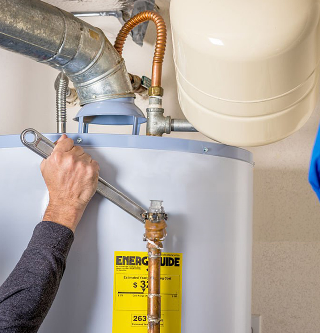 Technician inspecting a water heater tank for corrosion