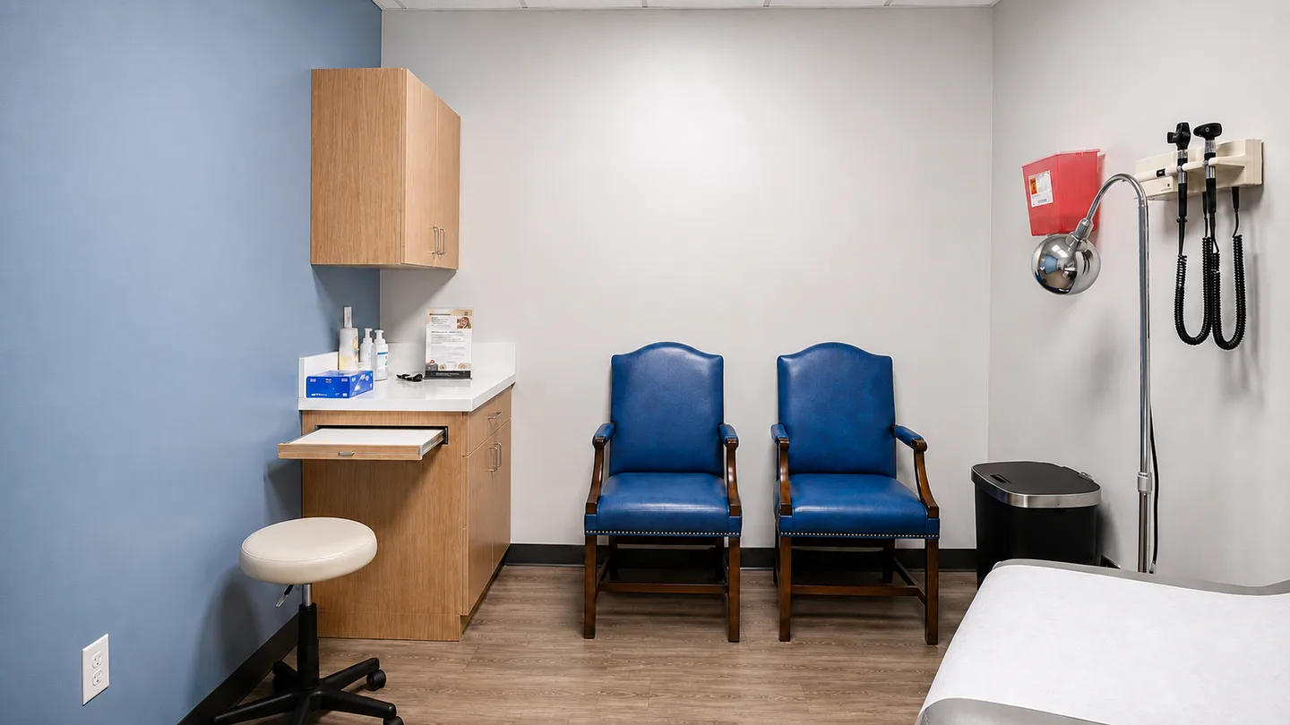 An exam room at Gem MD with patient seating and a physician’s stool