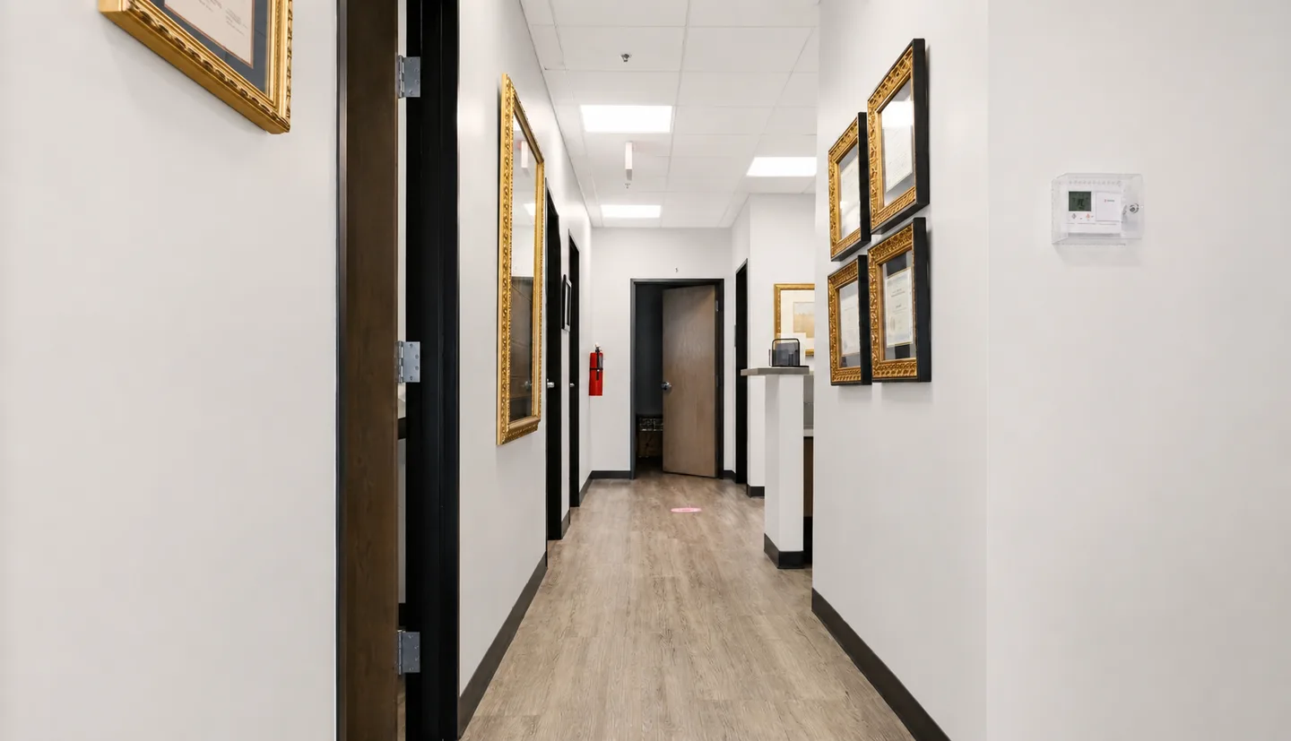 A hallway at Gem MD lined with framed medical credentials