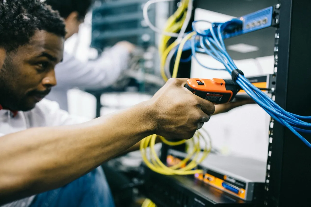 Data center technicians engaged in hands-on training session learning proper equipment maintenance procedures from certified instructor