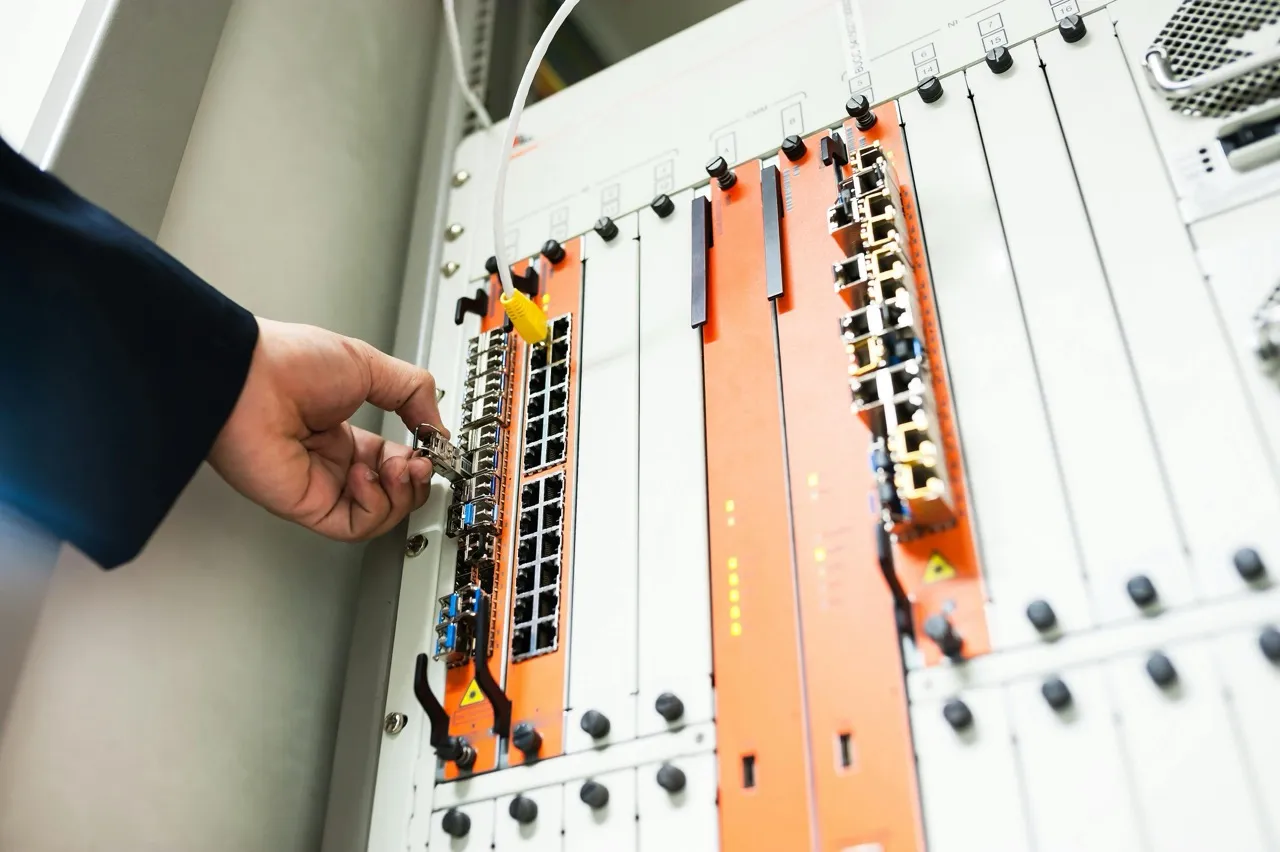Technician connecting a network cable into a data center server rack
